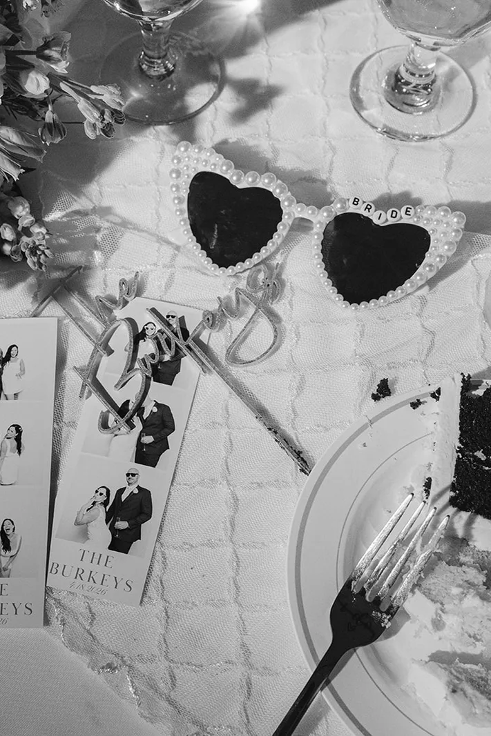 Black and white film strips, heart sunglasses, and cake on a reception table