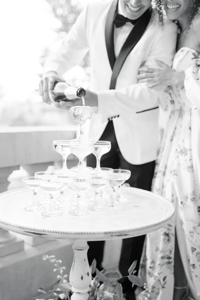 A champagne tower being poured in black and white