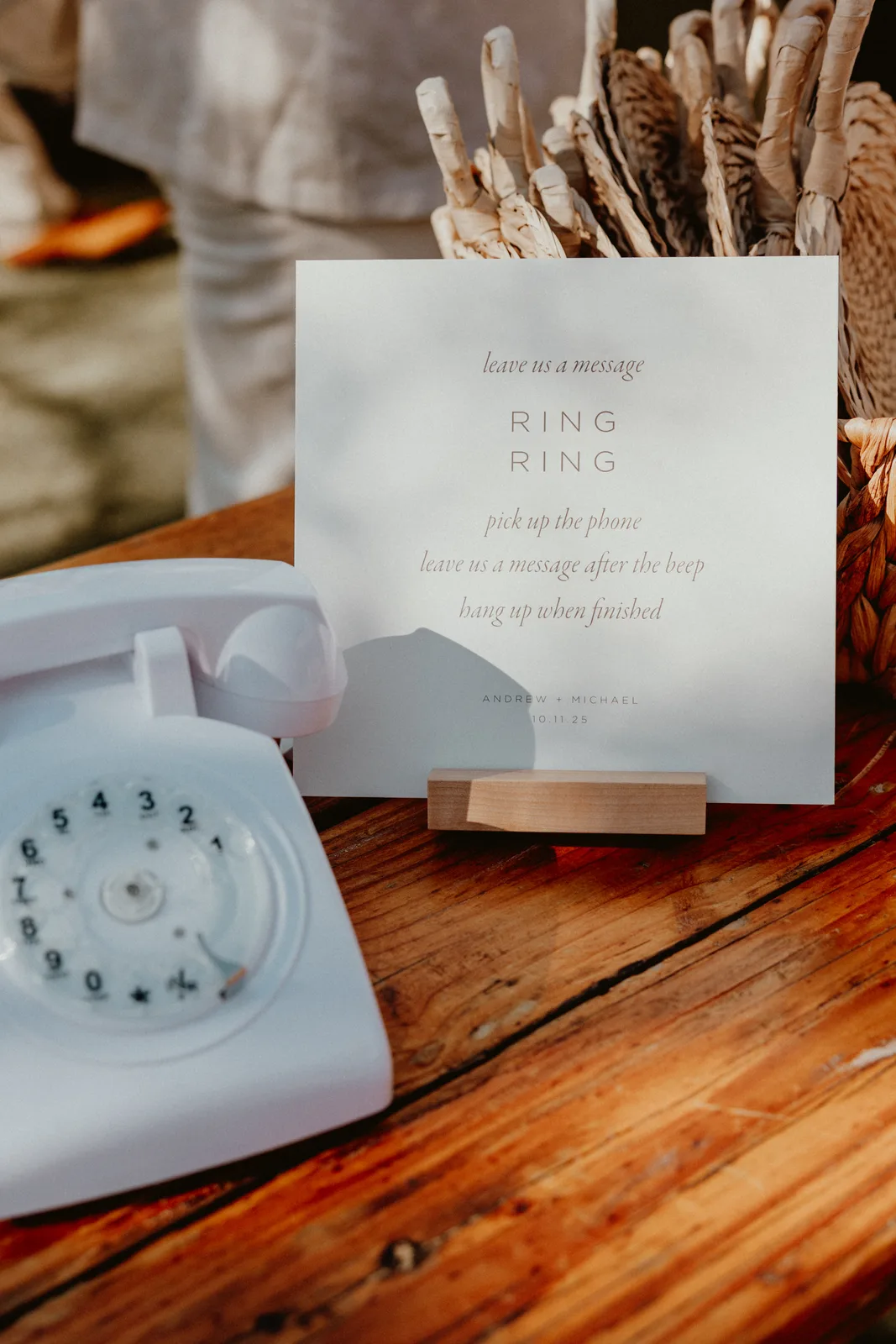 The audio guest book's white rotary phone beside its welcome sign on a wooden table