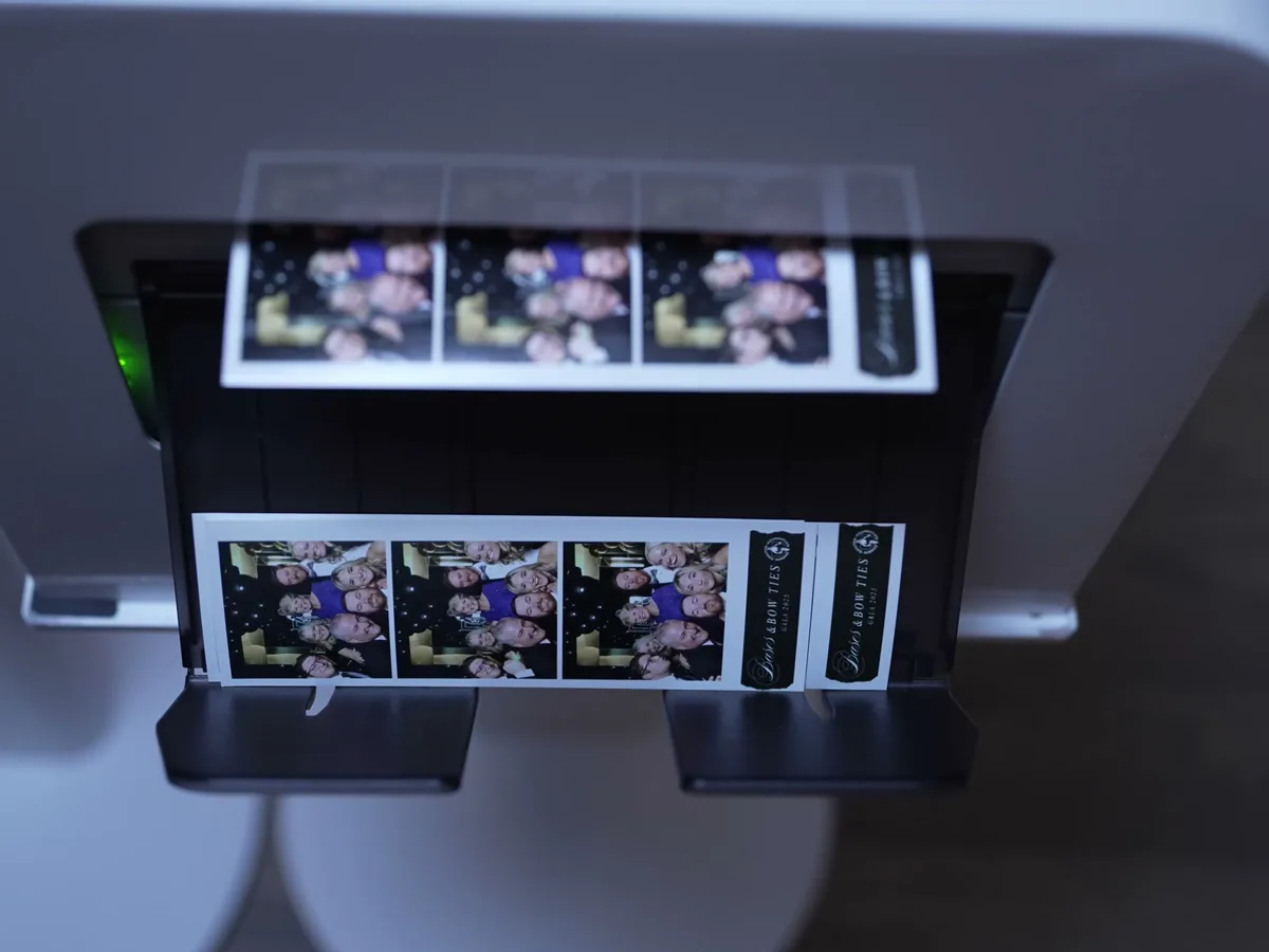 Film strips printing from the photo booth at a Viva Booth Co. event
