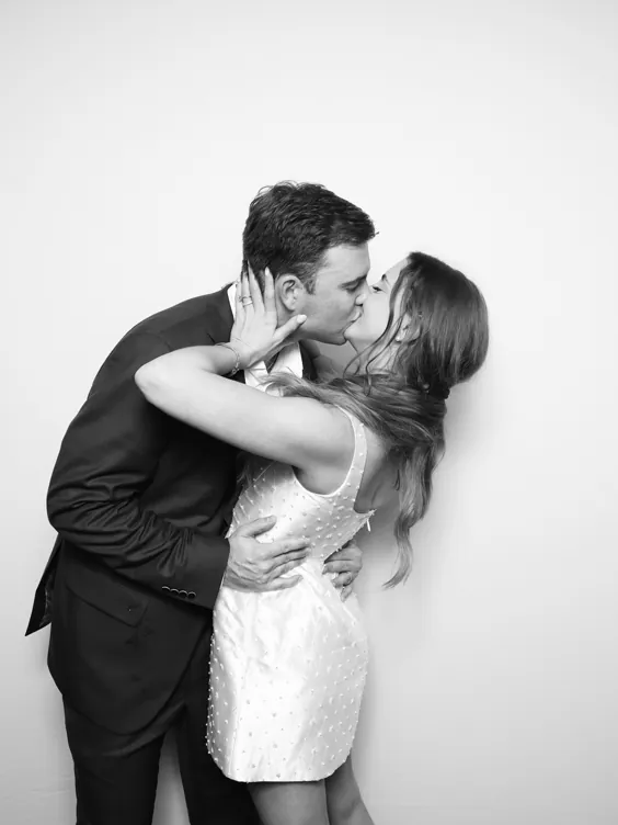 A couple in a black and white photo booth portrait against a white backdrop