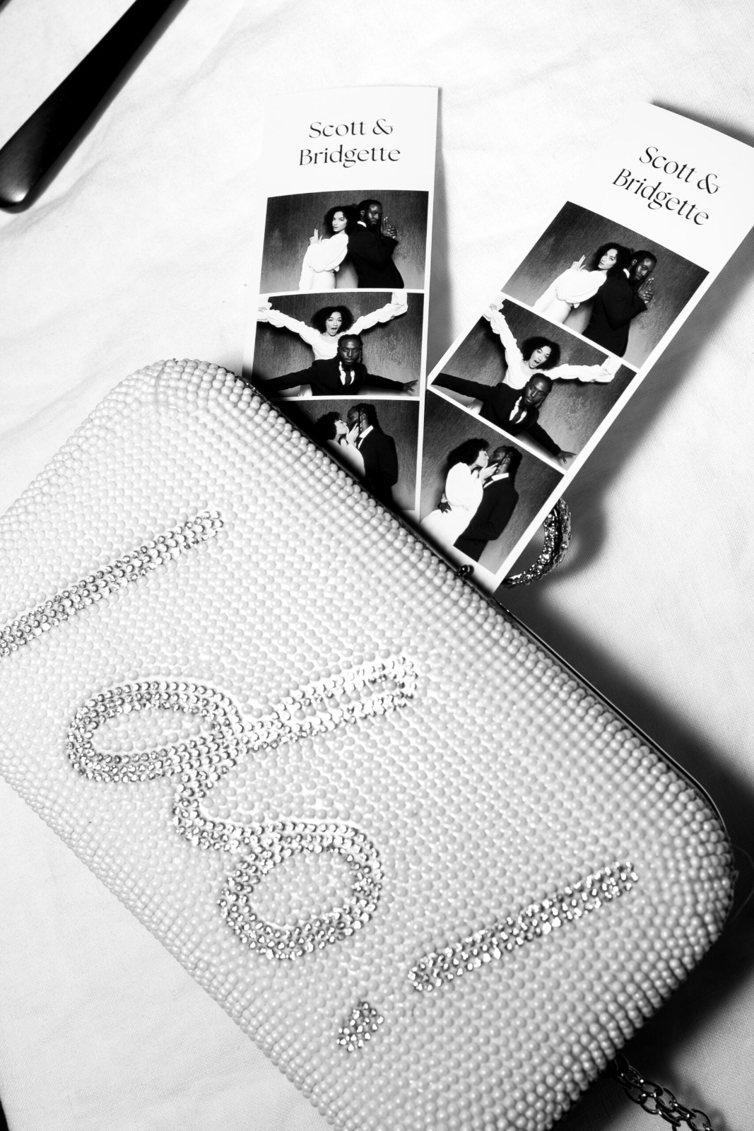 Black and white photo strips printed for Scott and Bridgette resting beside a beaded clutch
